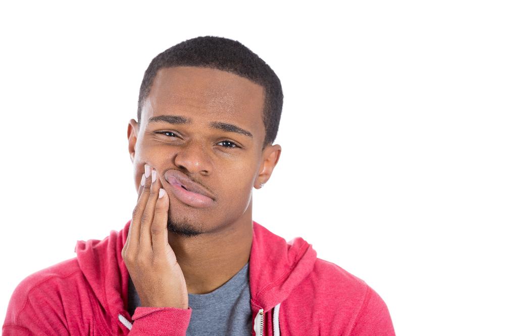 man in a dental pain holding his right cheek