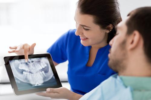 dentist showing x ray result to the patient