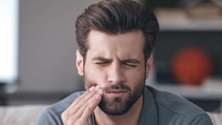 Man in a pain holding his check