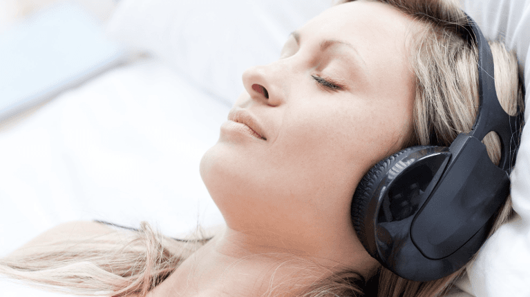 woman in headphones closing her eyes
