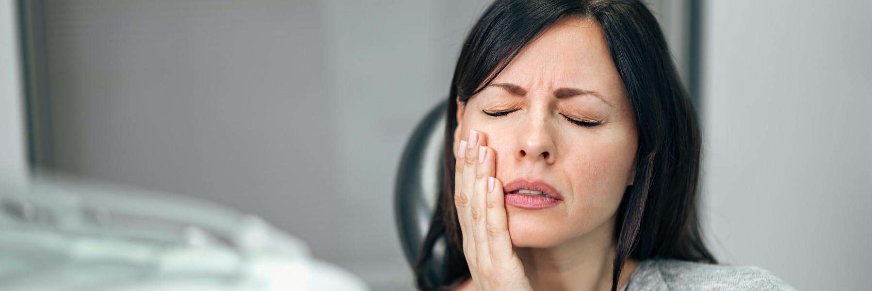 woman in pain holding her cheek